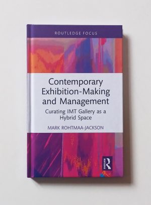 A cover of Mark’s book, released by Routledge in the Routledge Focus series. The image on the cover appears not dissimilar to sound spectrum analysis charts, with warm-coloured vertical visualisations of data. In its centre, a white text box displays the books title written in a modern-looking font: Contemporary Exhibition-Making and Management; Curating IMT Gallery as a Hybrid Space. Mark’s full name is visible directly beneath it.